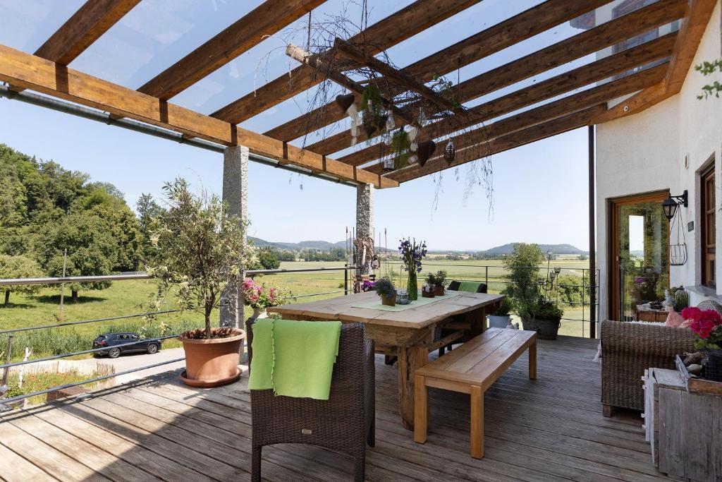 an outdoor deck with a wooden table and chairs at Almschlössle in Gottmadingen