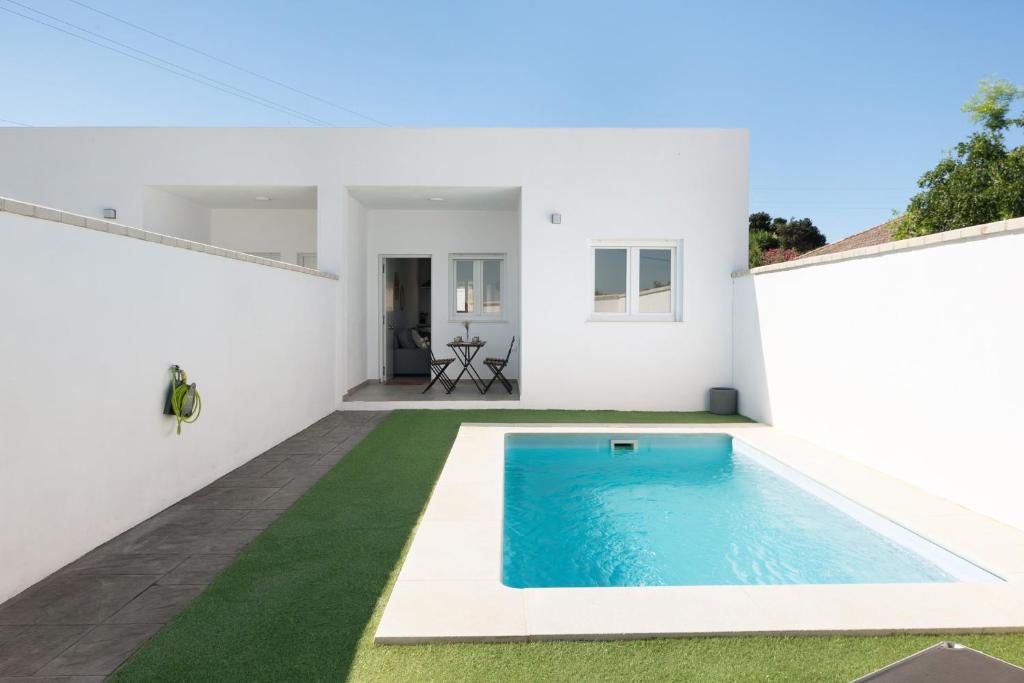 a swimming pool in the backyard of a white house at Casa Lavanda Vejer in La Muela