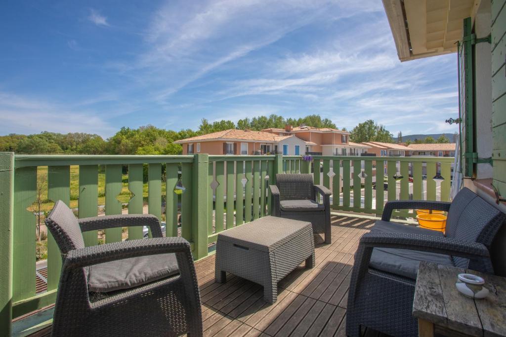 a deck with chairs and tables and a fence at T3 au calme avec terrasse in Cogolin