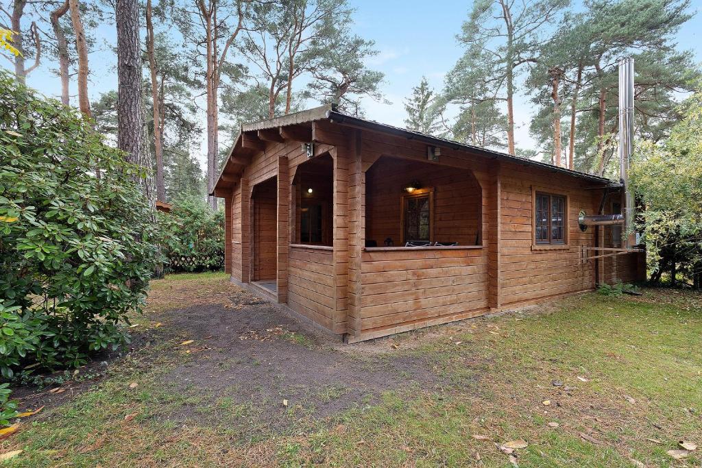 a small wooden cabin in the middle of a yard at Ferienhaus Waldblick in Berlin