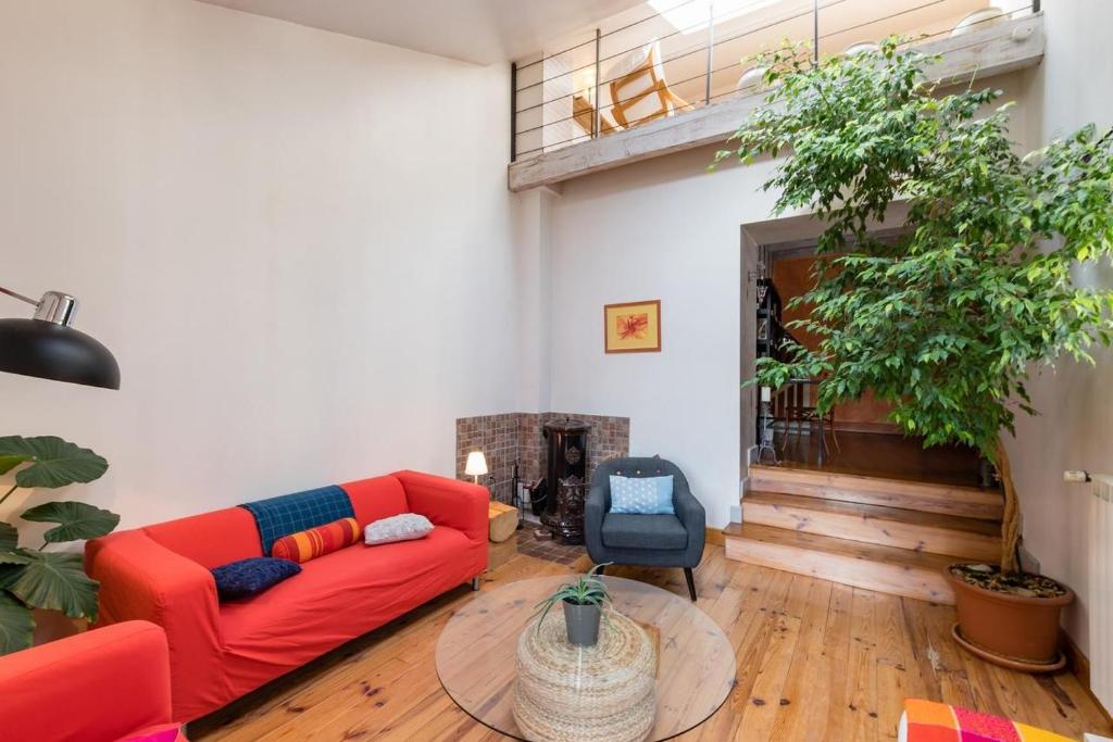 a living room with a red couch and a table at Cocon Familial - Gîte De Charme in Die