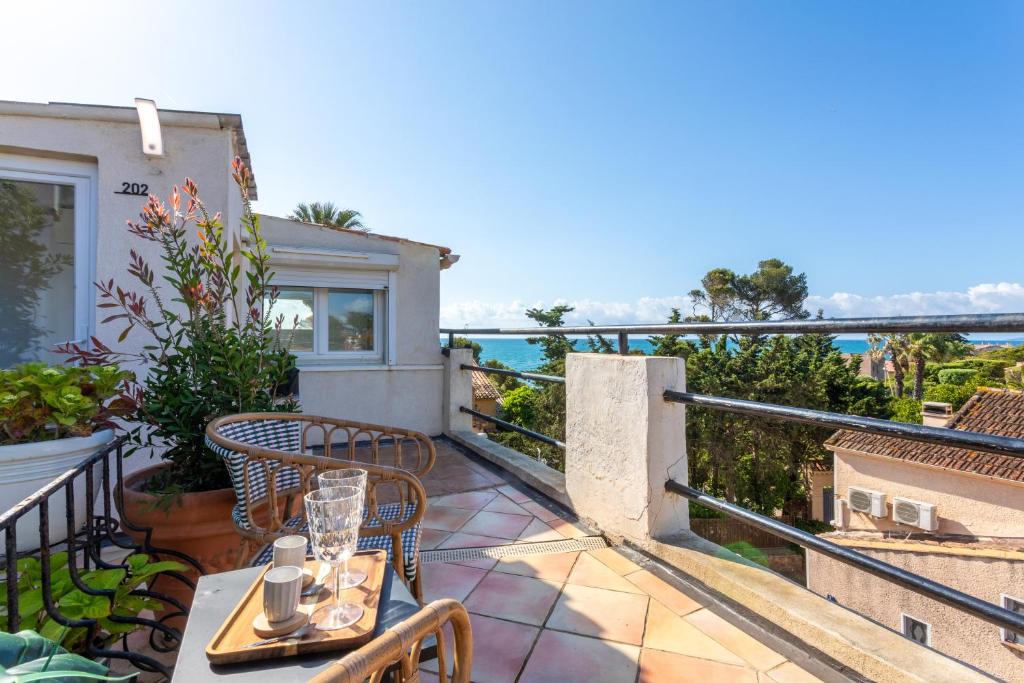 a balcony with a table and chairs and the ocean at L'Escale Au Soleil in Saint-Aygulf
