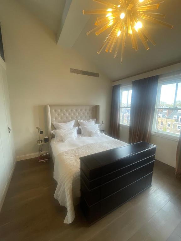 a bedroom with a large bed and a large chandelier at 51 Hotel Apartment in London