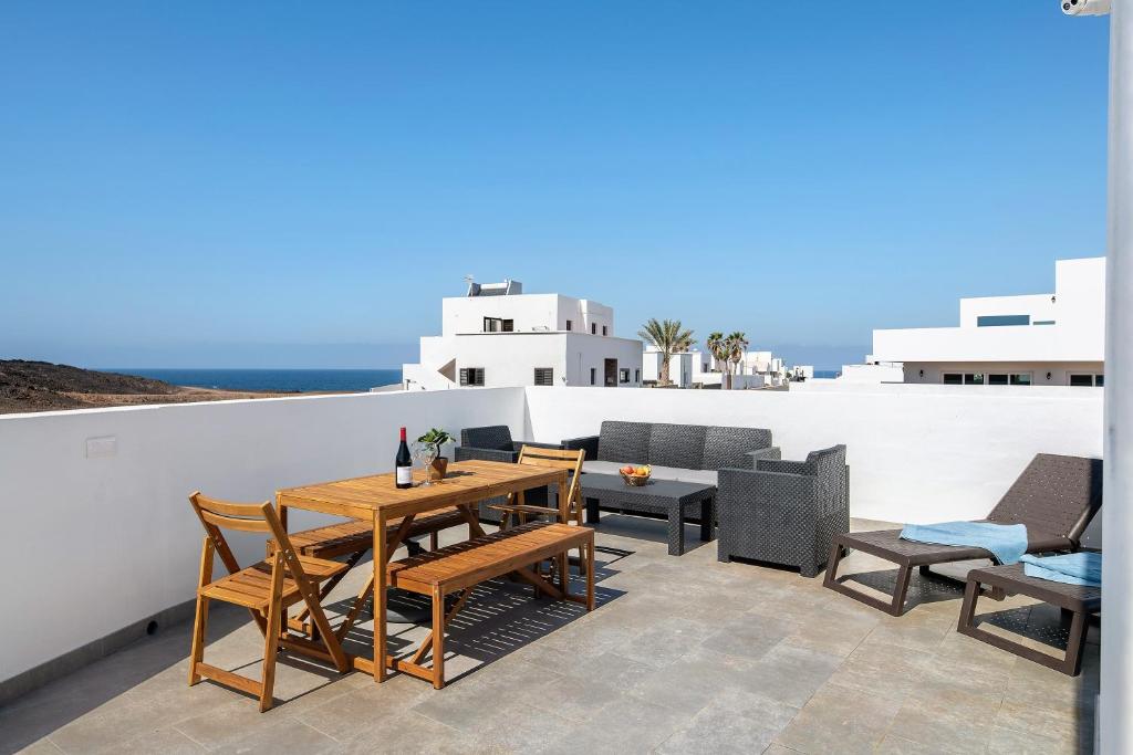 a patio with a wooden table and chairs at Ocean 1 in La Santa
