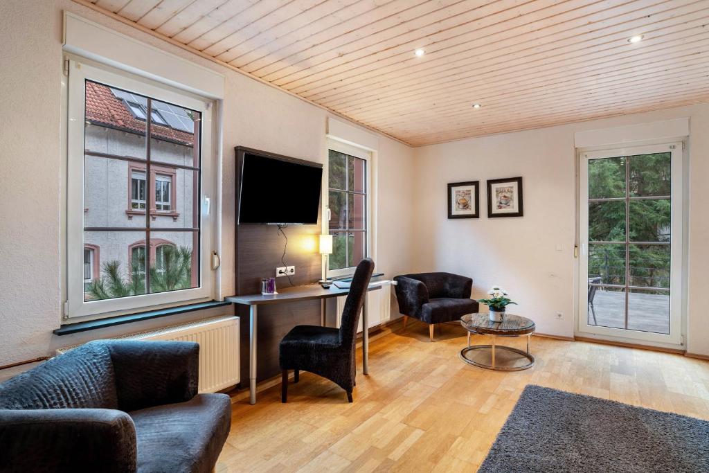 a living room with a desk with a computer and two chairs at Luise in Bad Bergzabern