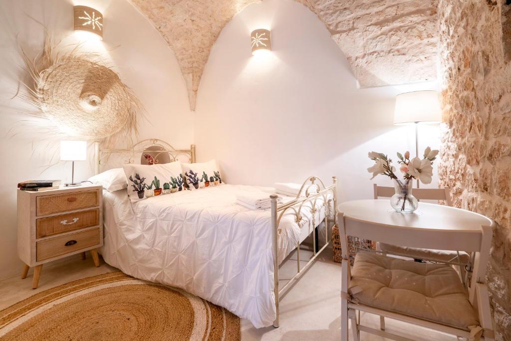 a small bedroom with a bed and a table at Suite Carlomaria in Ceglie in Ceglie Messapica