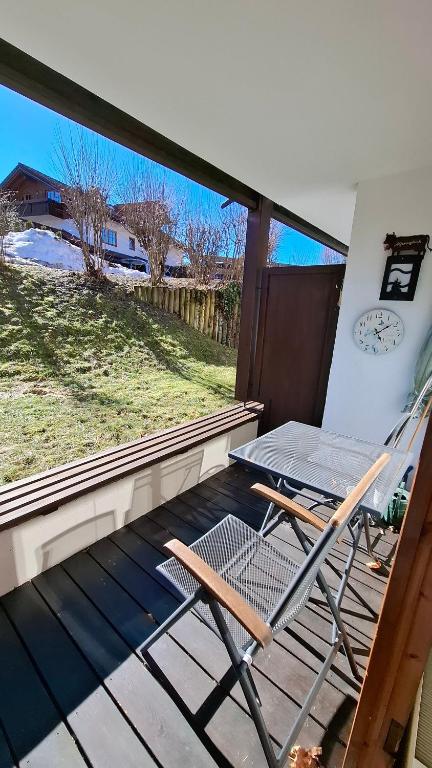 a patio with a chair and a table on a deck at Ferienwohnung Älple im Sonnenpark in Bad Hindelang