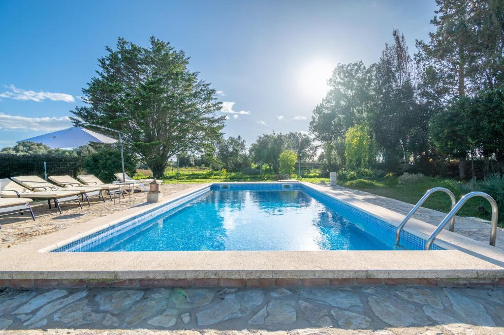 a swimming pool in a yard with chairs around it at Finca Cas Forner in Islas Baleares