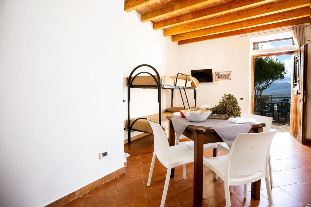 a dining room with a table and chairs and a bunk bed at Casa Atena in Motta D'affermo