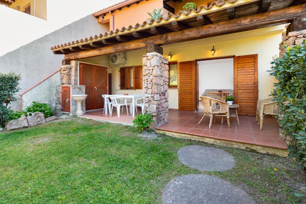 a patio of a house with a table and chairs at Holiday house li Piri in San Teodoro