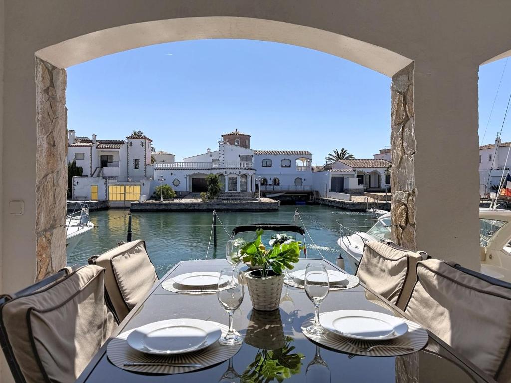 a table on a balcony with a view of the water at Holiday Home Salins by Interhome in Empuriabrava