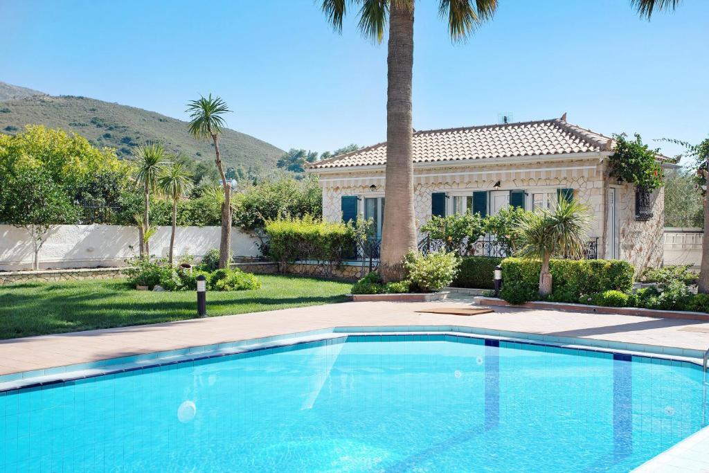 a large swimming pool in front of a house at Olympia Holiday Home in Zakynthos