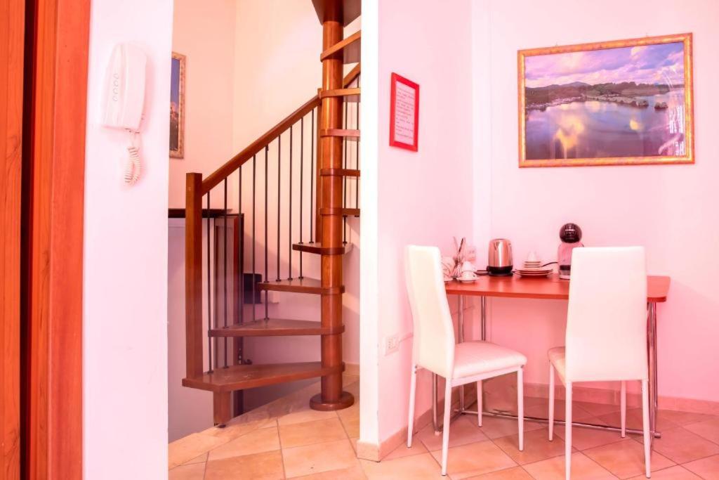 a dining room with a table and white chairs at B&B Pedruzza in Alghero