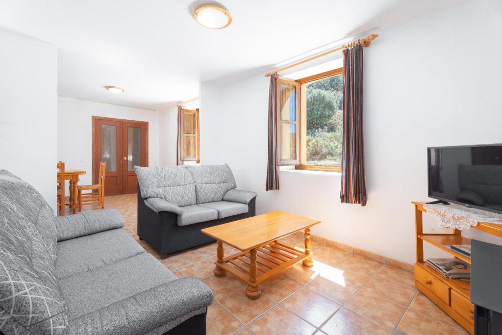 a living room with a couch and a tv at Antiga escola de Molinell in Culla