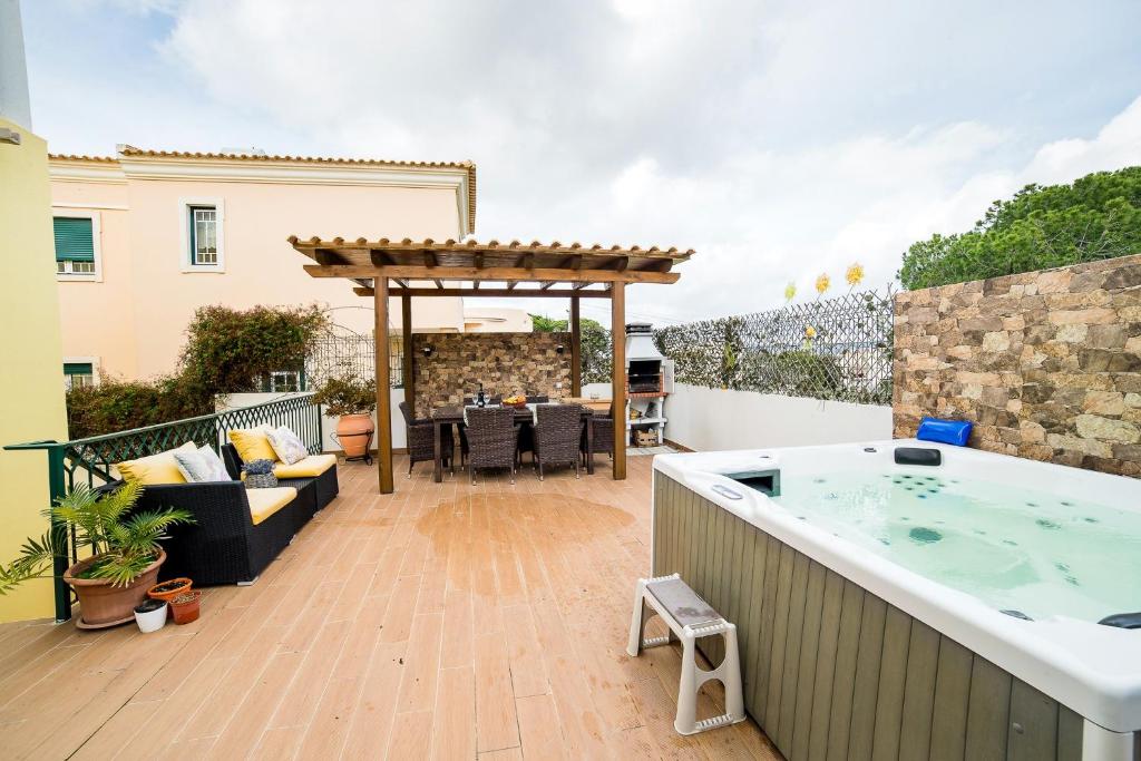 a patio with a hot tub and a table at Laguna Formosa in Faro