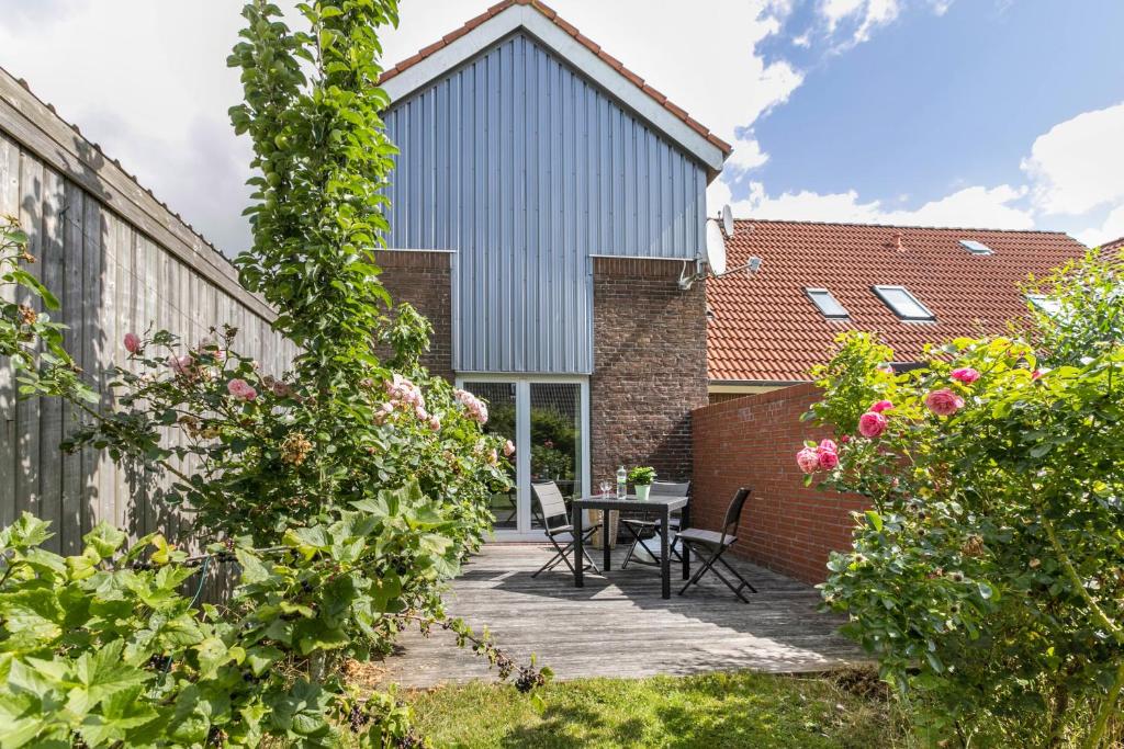 a garden with a table and chairs in front of a building at Niebüllhus in Niebüll