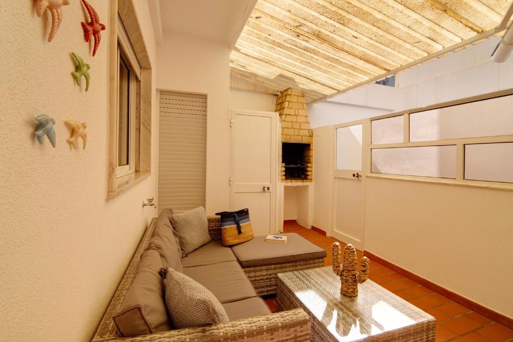 a living room with a couch and a table at Âncora B in Monte Gordo