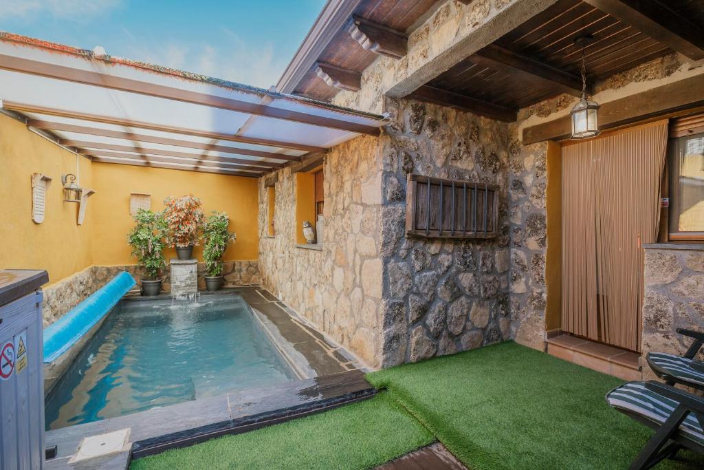 an indoor pool in a house with green grass at Casa Las Tres Coteras in Muñopedro
