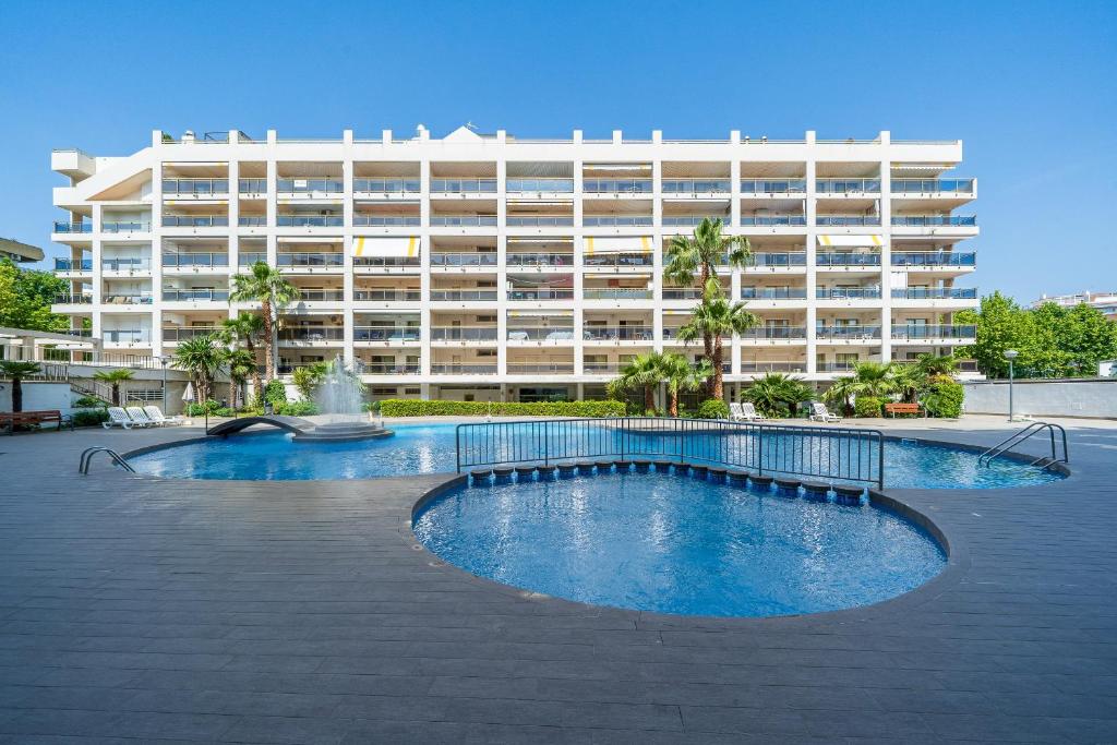 a large building with a swimming pool in front of a building at Apartamentos Salou - 112 in Salou
