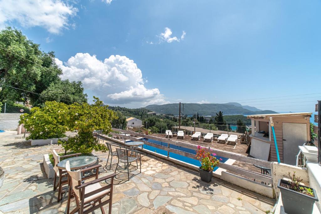 a patio with a table and chairs and a pool at Spyridoula Studio 11 in Paleokastritsa