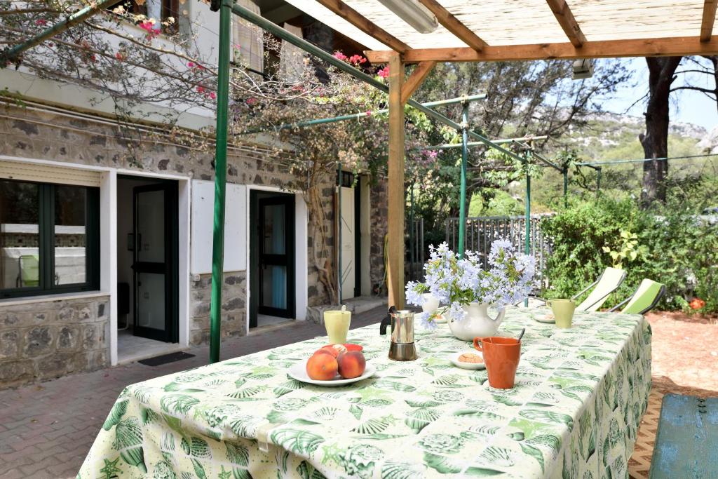 a table with a green and white table cloth with fruit on it at Appartamento Pini in Cala Gonone