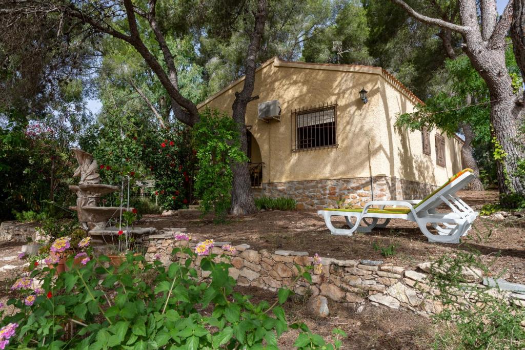 a house with a bench and a house with trees at Las Pedrizas in Pilar de la Horadada