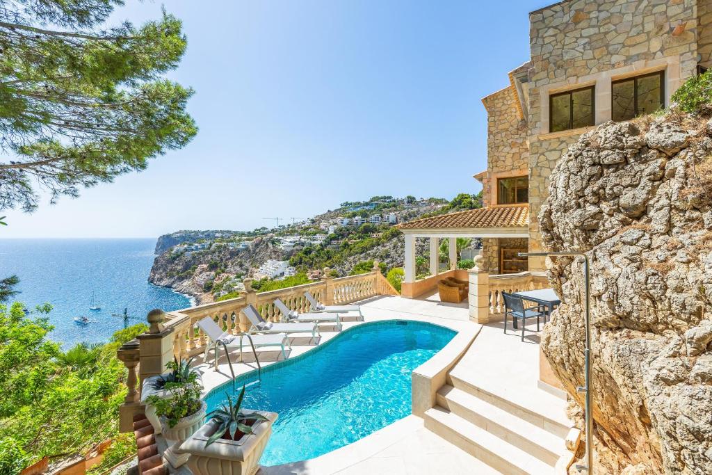 a villa with a swimming pool and a view of the ocean at Villa Cala Llamp in Port d'Andratx