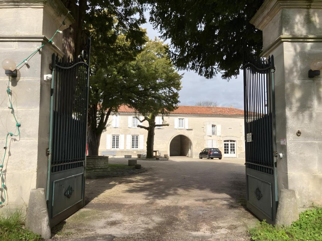 an open gate to a house with a car parked at Chez Bilhouet in Segonzac