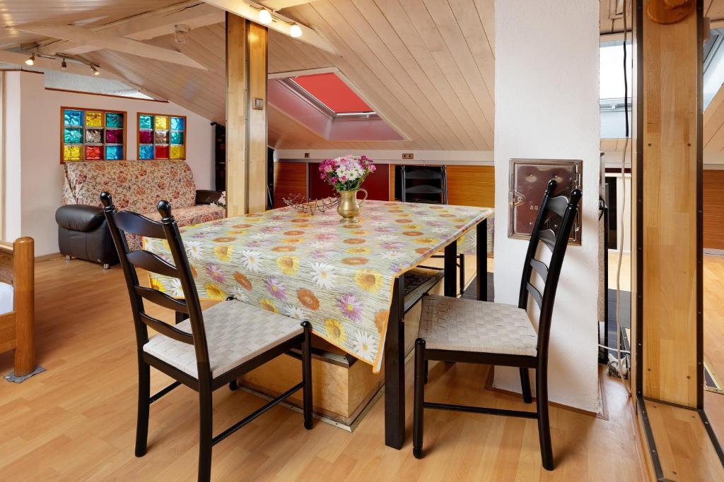 a dining room table with chairs and a vase of flowers on it at Haus Schwanenweg in Konstanz
