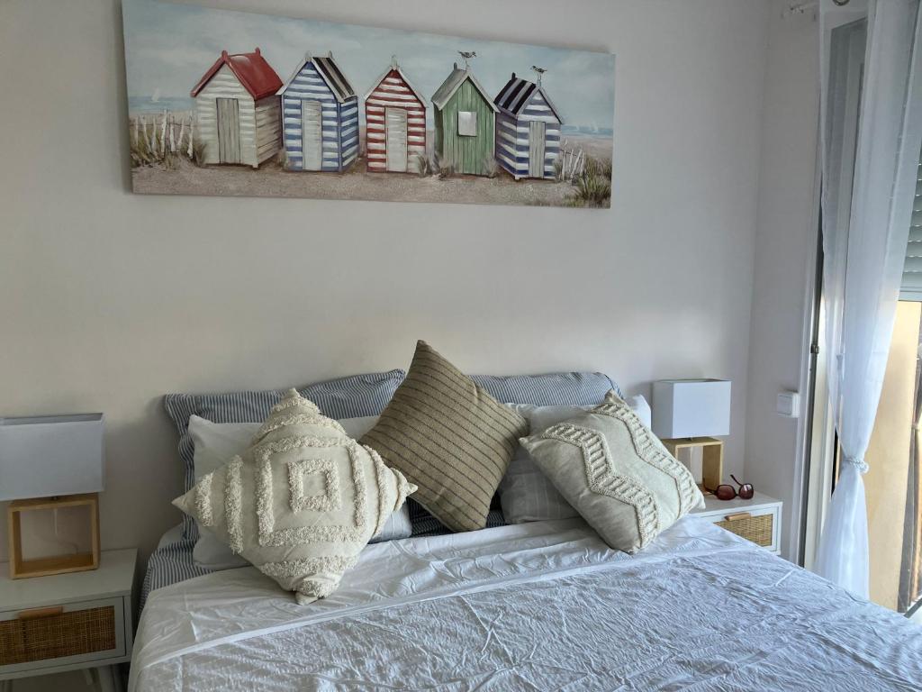 a bedroom with a bed with a painting of beach houses at Costa Brava beach studio in Sant Antoni de Calonge