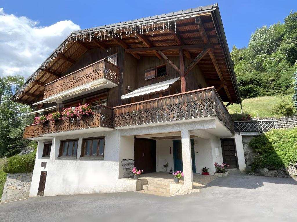 a house with a balcony with flowers on it at Chalet Arnica in Morzine