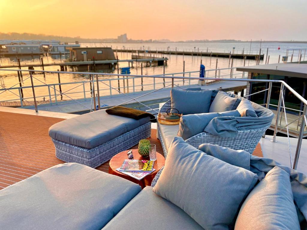 a boat with couches and a table on the deck at Hausboot inkl Motorboot, Ostsee in Heiligenhafen