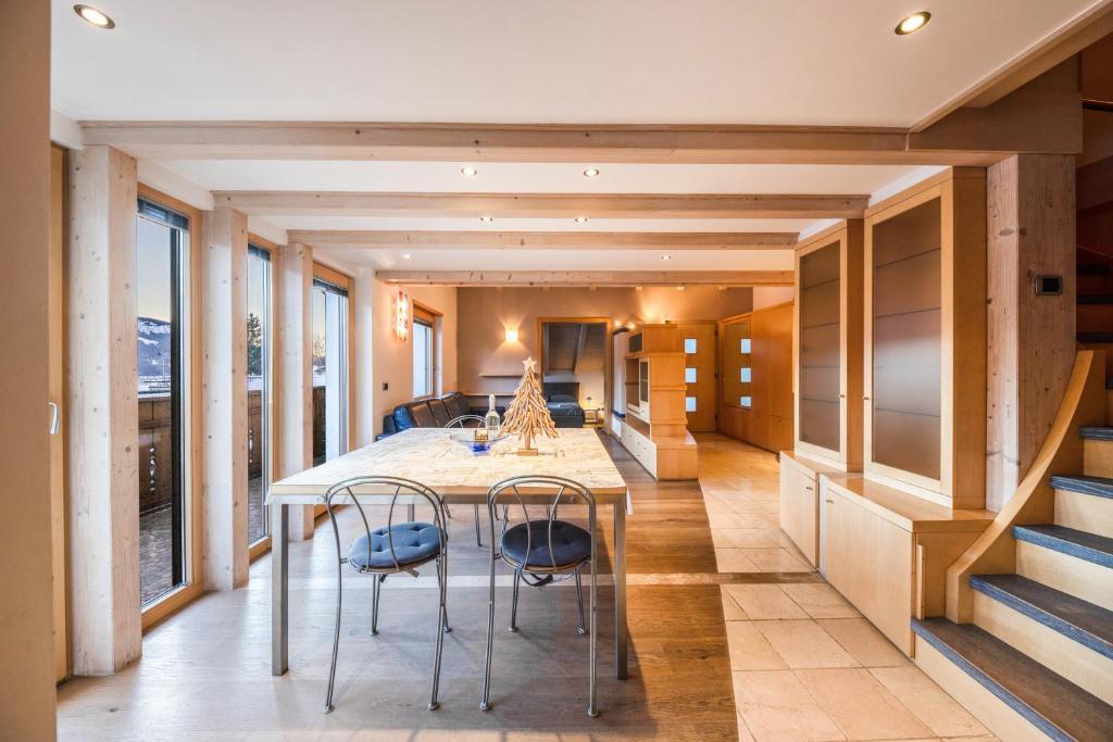 a kitchen and dining room with a table and chairs at La Pratolina Attico in Castello di Fiemme