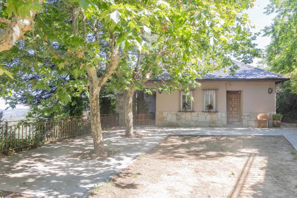 a house with trees in front of it at Espacio Rural La Cabaña de Miraflores in Miraflores de la Sierra