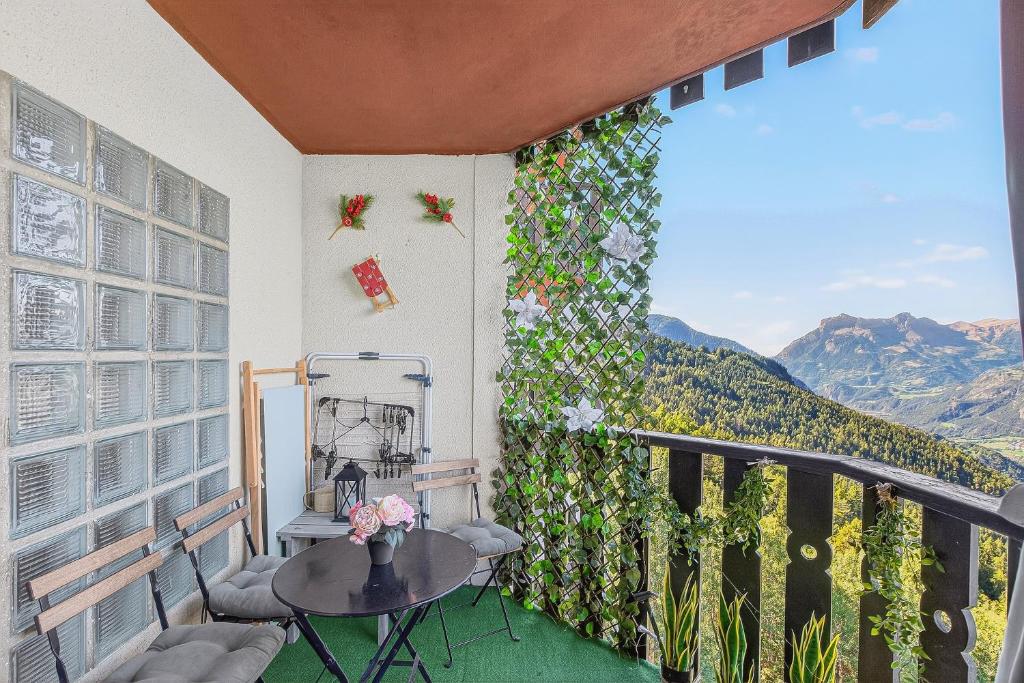 a balcony with a table and a view of mountains at Cosy 4p, Pied des Pistes, Pra Loup in Uvernet