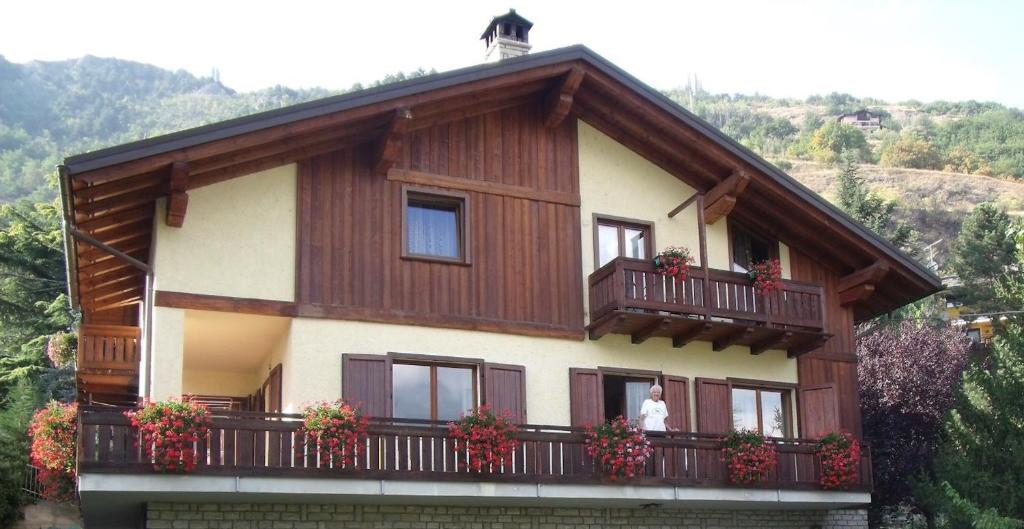 a house with a balcony with flowers on it at Pelòt-de la Masse in Aosta