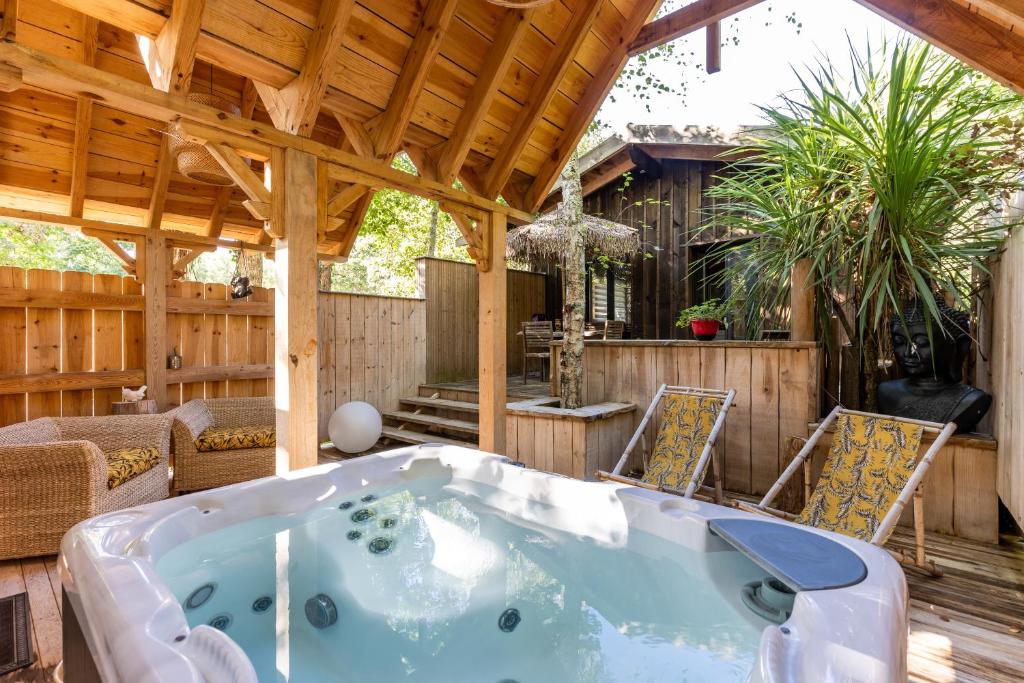 a jacuzzi tub in a wooden house at Chalet Savannaketh in Lacanau