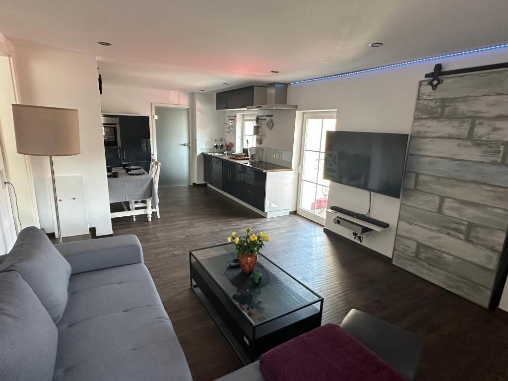 a living room with a couch and a table and a kitchen at Bergisch Resort Josef in Lindlar