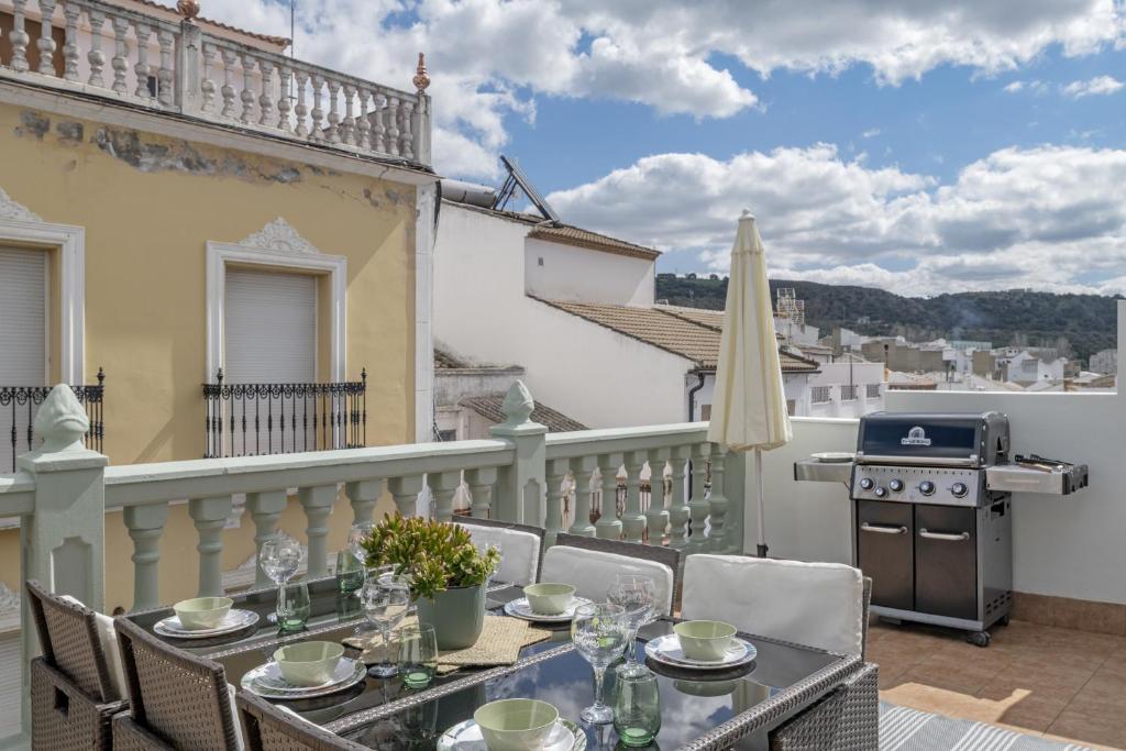 a table and chairs on a balcony with a grill at Barsanz Palace Home in Alcalá del Valle