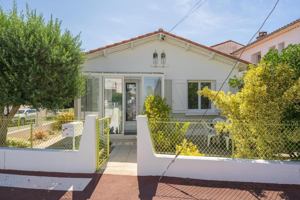 a white house with a fence in front of it at Maison Individuelle, Royan Centre in Royan