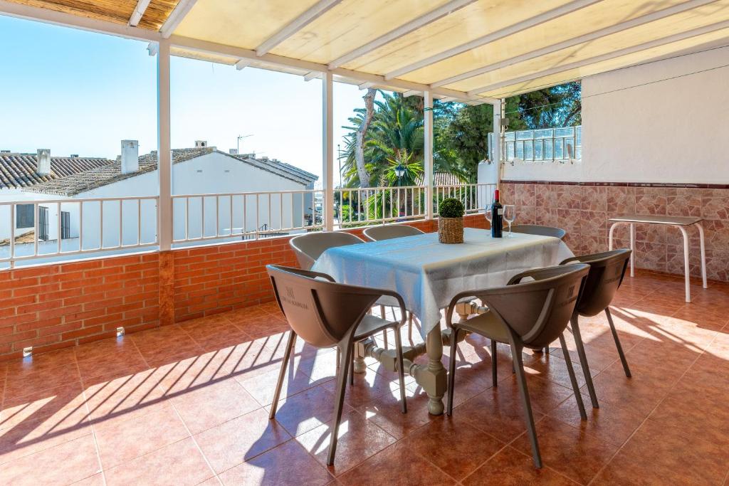 a room with a table and chairs on a balcony at Casa Pepe junto al mar in Benajarafe