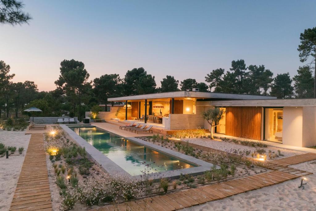 a house with a swimming pool in front of it at M Villa Comporta Retreat in Carvalhal