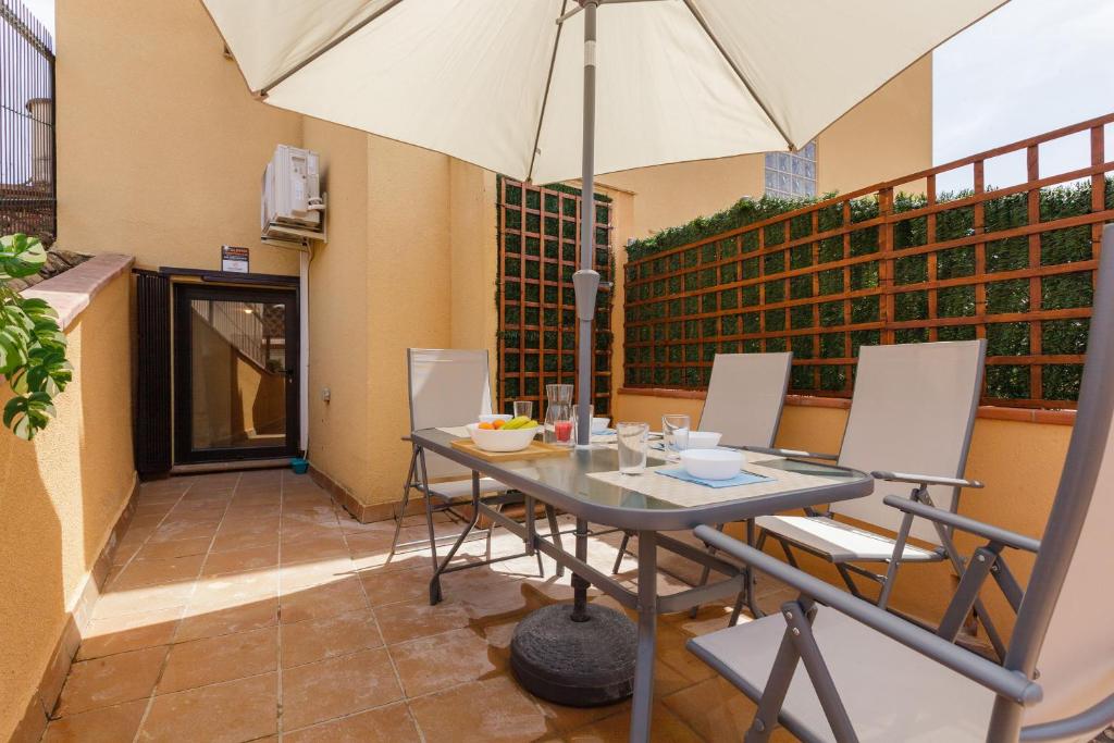 a table and chairs with an umbrella on a balcony at Sauc Beach Apartment in Canet de Mar