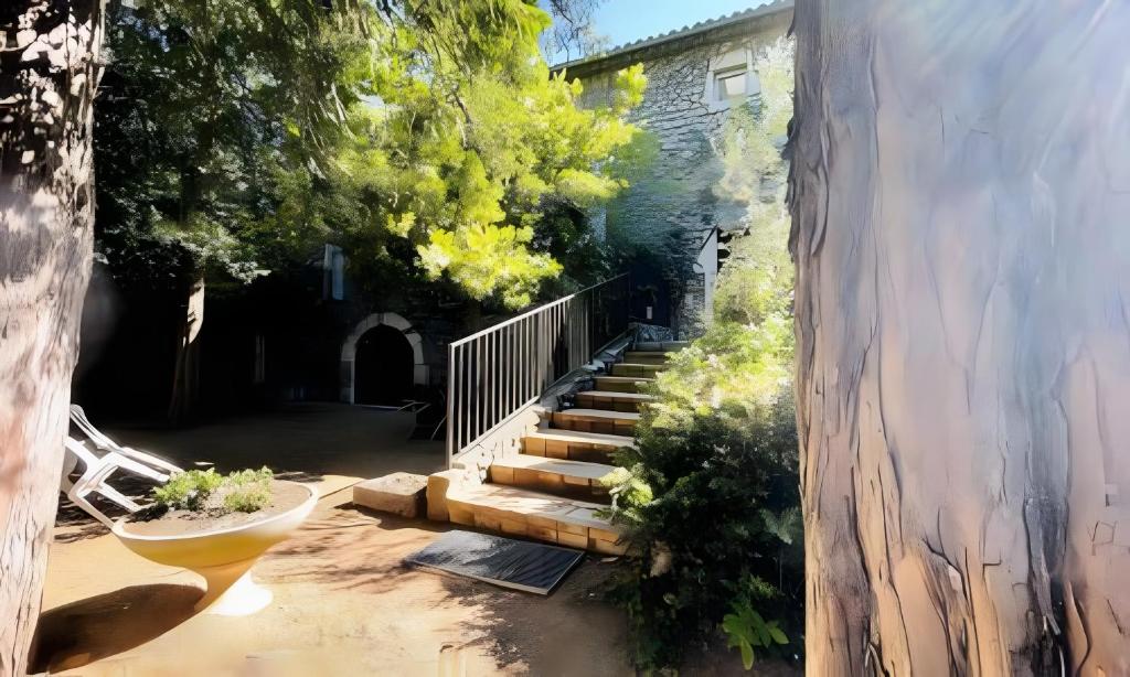 a stairway leading up to a building with trees at Gîtes du Parc in Vallon-Pont-dʼArc