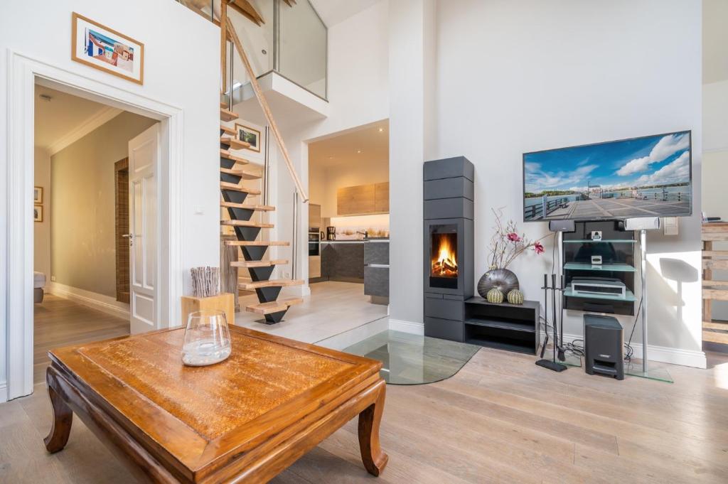 a living room with a table and a fireplace at Appartement Halbinsel Wittow in Binz