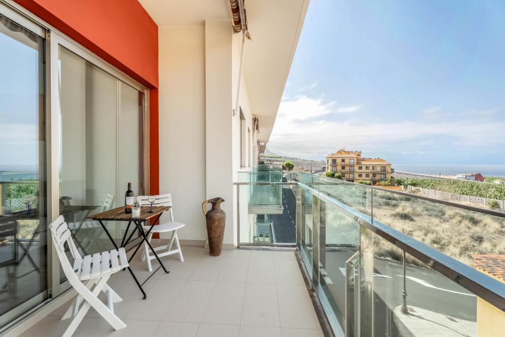 a balcony with a table and chairs and a view of the ocean at Casa Graham 14 in Tazacorte