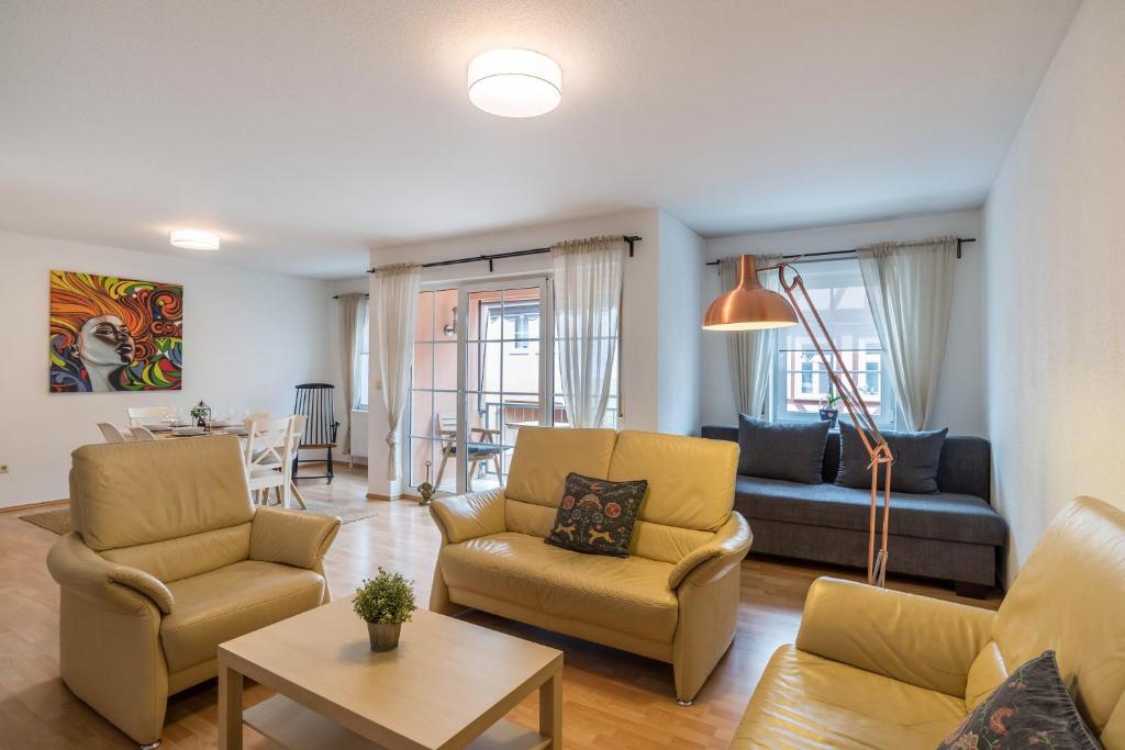 ein Wohnzimmer mit Sofa, Stühlen und einem Tisch in der Unterkunft Aposto Apartments 2 in Oberderdingen