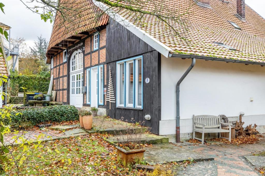 a black and white house with a bench in front of it at Alter Laden in Nienstädt