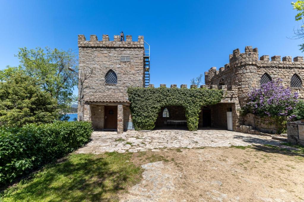 an old stone house with ivy growing on it at Isla Del Burguillo in Ávila