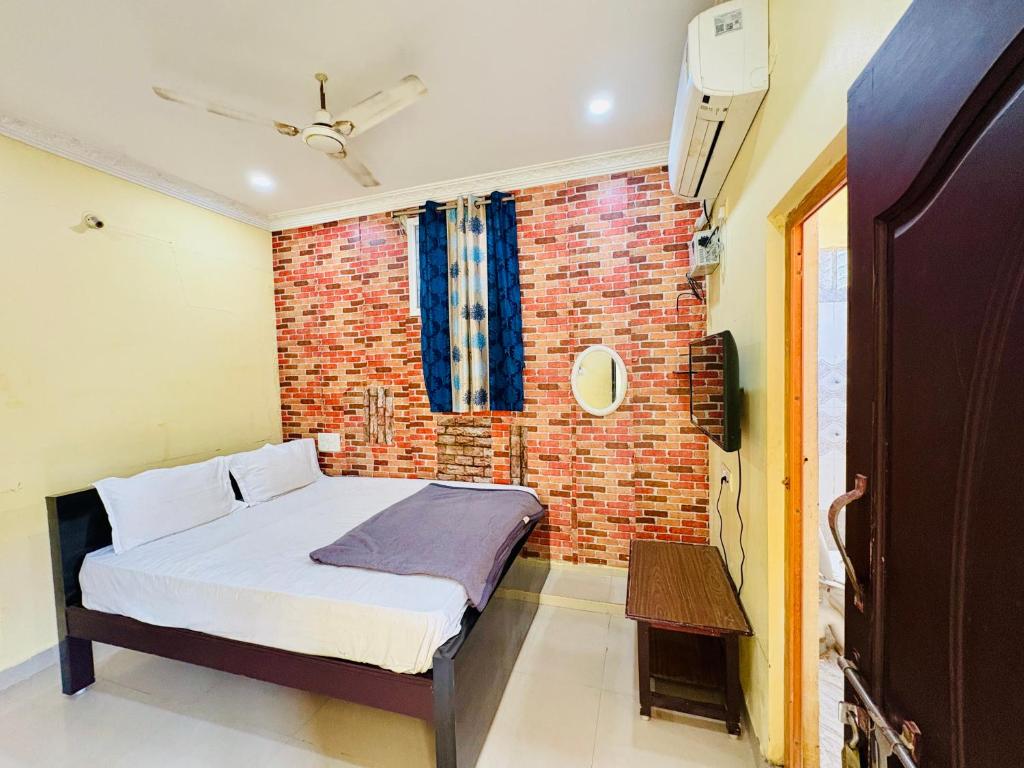 a bedroom with a brick wall and a bed at MSN-Gate1Temple in Srikalahasti